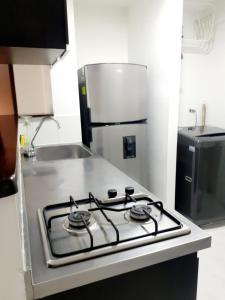 a stove top oven in a kitchen with a refrigerator at Apartamento centro MDE in Medellín