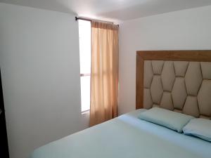a bedroom with a large bed and a window at Apartamento centro MDE in Medellín