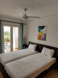a bedroom with two beds and a ceiling fan at La Casa Mima Penthouse at Hacienda Riquelme in Sucina +22 photos