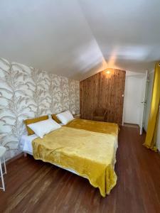 um quarto com uma cama grande e um cobertor amarelo em SOURCE D'HARMONIE L'Écureuil Terres Rouges La Rocaille l'Olivier em Meyreuil