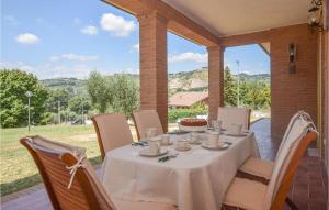 een tafel met een witte tafellaken op een patio bij Lovely Home In Castelnuovo Di Farfa With Kitchen in Castelnuovo di Farfa