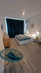 ein Schlafzimmer mit einem Bett, einem Stuhl und einem Tisch in der Unterkunft Unique Experience Apartment’s in Thessaloniki