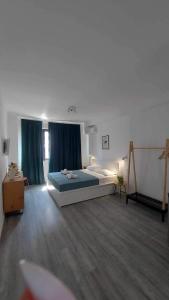 a bedroom with a large bed and blue curtains at Unique Experience Apartment’s in Thessaloniki