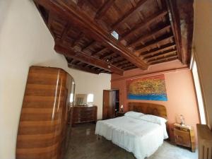 Supino的住宿－Casina di Paolo e Maria，卧室配有一张床,墙上挂有绘画作品