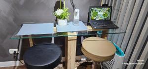 a glass desk with a laptop computer and a stool at SMDC AIR RESIDENCES in Manila +15 photos