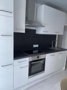 a white kitchen with a stove and white cabinets at Apartment in Velden am Wörthersee, Top 4 in Velden am Wörthersee