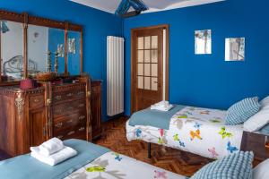 um quarto azul com duas camas e uma cómoda em Casa Morè em Camo