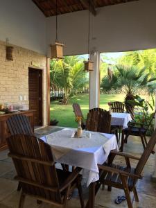 uma mesa de jantar com cadeiras e uma toalha de mesa branca em Pousada Melgaço em Icaraí