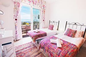 a bedroom with two beds and a balcony at Villa Yolanda del Mar in Arroyo de la Miel