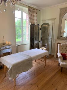 sypialnia z dużym łóżkiem i krzesłem w obiekcie Manoir de Bel Ébat w mieście Crossac