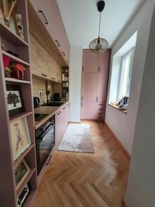 a kitchen with pink cabinets and a window at Spacious and quiet 1BR apartment in Floreasca in Bucharest