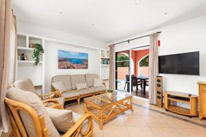 a living room with a couch and a tv at Villas Cala Galdana in Cala Galdana