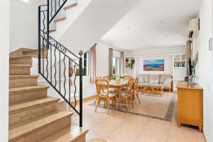 a dining room and living room with a table and chairs at Villas Cala Galdana in Cala Galdana