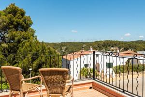 two chairs on a balcony with a view at Villas Cala Galdana in Cala Galdana