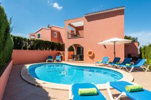 a villa with a swimming pool in front of a house at Villas Cala Galdana in Cala Galdana