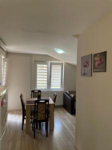 - une cuisine et une salle à manger avec une table et des chaises dans l'établissement Apartmani Vrla, à Vladičin Han