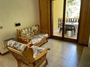a living room with a couch and chairs and a balcony at NadSan Mountain House in Camigliatello Silano