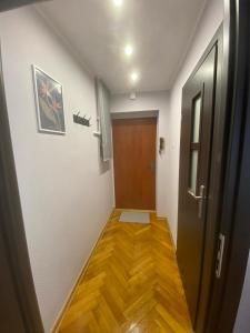 a hallway with a door and a wooden floor at Night Host Matejki 4 in Bytom