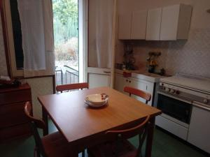a kitchen with a wooden table and chairs and a table and a window at Villetta Alberti in Sanremo