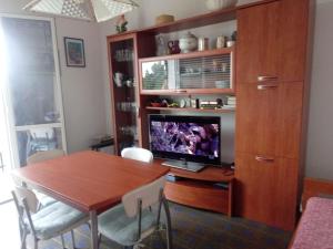 a dining room with a table and a television in a cabinet at Villetta Alberti in Sanremo