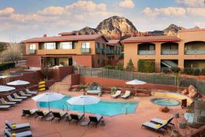 a hotel patio with a pool and chairs and umbrellas at The Wilde Resort and Spa in Sedona