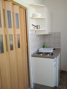 a kitchen with a sink and a stove and cabinets at Apartmani Carević in Baška Voda