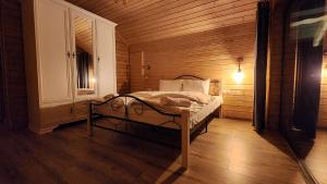 um quarto com uma cama num quarto de madeira em Cabanele CARMEL em Muntele Rece