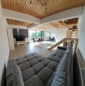 uma sala de estar com um sofá e uma sala de jantar em Cabanele CARMEL em Muntele Rece