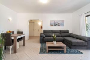 - un salon avec un canapé et une table dans l'établissement Lively Charming Apartment w Pool, à Praia do Carvoeiro