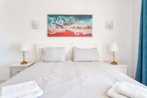 - une chambre avec un grand lit blanc et deux lampes dans l'établissement Lively Charming Apartment w Pool, à Praia do Carvoeiro
