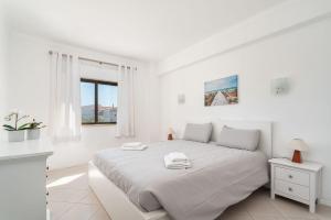 - une chambre blanche avec un lit blanc et une fenêtre dans l'établissement Lively Charming Apartment w Pool, à Praia do Carvoeiro