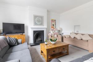 a living room with two couches and a tv at Fabulous, vibrant, town house, central Bath Road in Cheltenham
