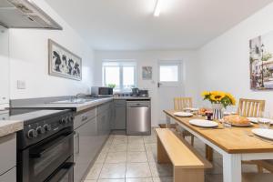 Fabulous, vibrant, town house, central Bath Road في تشلتنهام: مطبخ مع طاولة وغرفة طعام