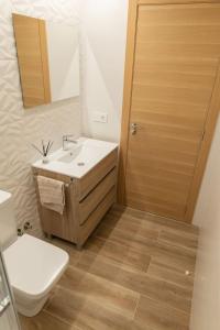 a bathroom with a sink and a toilet and a mirror at Casa Tía Pepa 