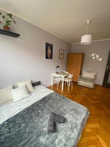 a bedroom with a large bed and a table at Night Host Matejki 4 in Bytom