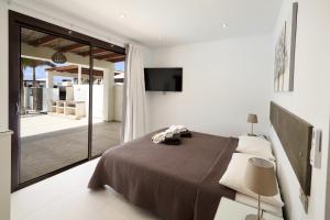 a bedroom with a bed and a sliding glass door at Villa Bella Valen - LH170 By Villas Now Ltd in Playa Blanca