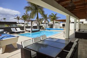 a patio with a pool and a table and chairs at Villa Bella Valen - LH170 By Villas Now Ltd in Playa Blanca