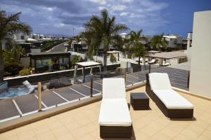 two white benches sitting on top of a building at Villa Bella Valen - LH170 By Villas Now Ltd in Playa Blanca