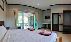 a bedroom with a large bed with pink pillows on it at The Zohan Resort & Travel Agency in Wok Tum