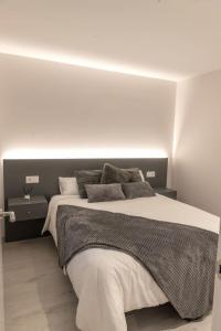 a bedroom with a large bed with a white wall at Casa Tía Pepa in Castenda
