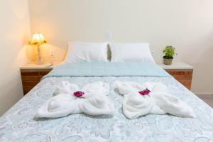 Una cama con toallas blancas encima. en Rifugio en Alto Paraíso de Goiás