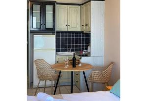 a small kitchen with a table with wine glasses on it at Sunset Premium Studio 6 in Agios Nikitas