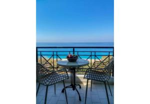 a table and chairs on a balcony with the ocean at Sunset Premium Studio 6 in Agios Nikitas