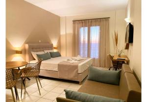 a hotel room with a bed and a table and chairs at Sunset Premium Studio 6 in Agios Nikitas