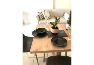 a table with two black plates and a plant on it at Sunset Premium Studio 6 in Agios Nikitas