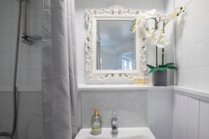 a white bathroom with a mirror and a sink at Fabulous, vibrant, town house, central Bath Road in Cheltenham +43 photos