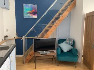 a living room with a tv and a chair at Beautiful Brighton Home in Brighton & Hove