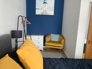 a bedroom with a yellow bed and a chair at Beautiful Brighton Home in Brighton & Hove