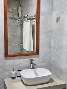 a bathroom with a white sink and a mirror at White Sand Inn in Maamigili