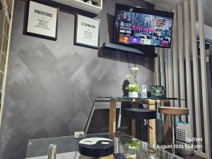 a bar with two stools and a tv on a wall at SMDC AIR RESIDENCES in Manila